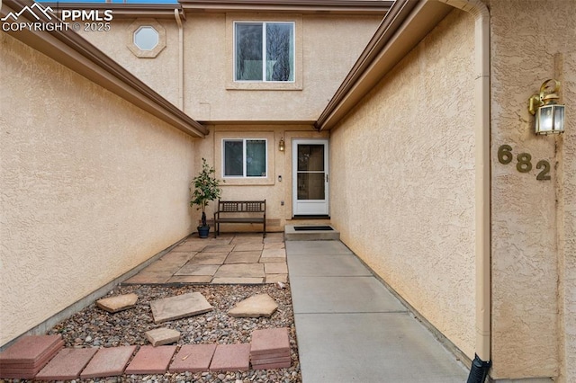 property entrance with a patio and stucco siding