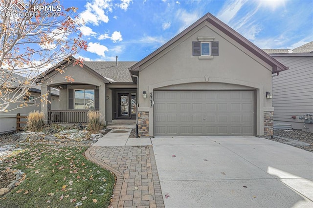 view of front of property with an attached garage, stone siding, concrete driveway, roof with shingles, and stucco siding