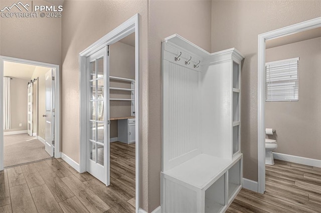 mudroom featuring french doors, light wood-style flooring, and baseboards