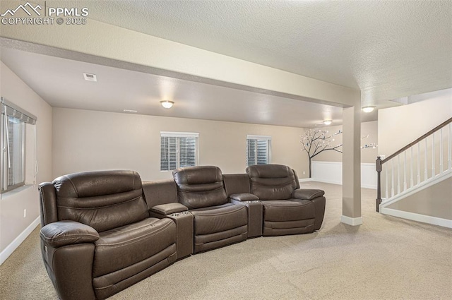 cinema with light carpet, visible vents, baseboards, and a textured ceiling