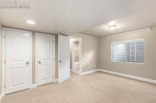 unfurnished bedroom featuring carpet flooring, visible vents, and baseboards