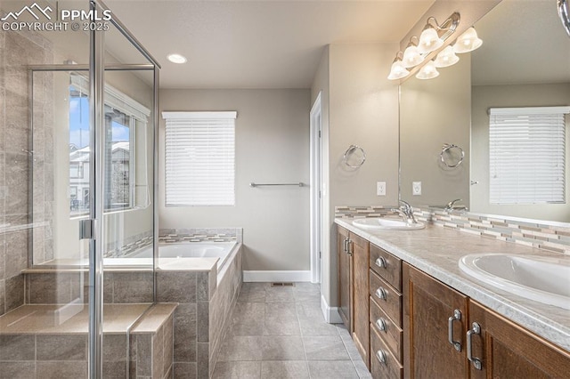 full bath with double vanity, a sink, a bath, baseboards, and tile patterned floors