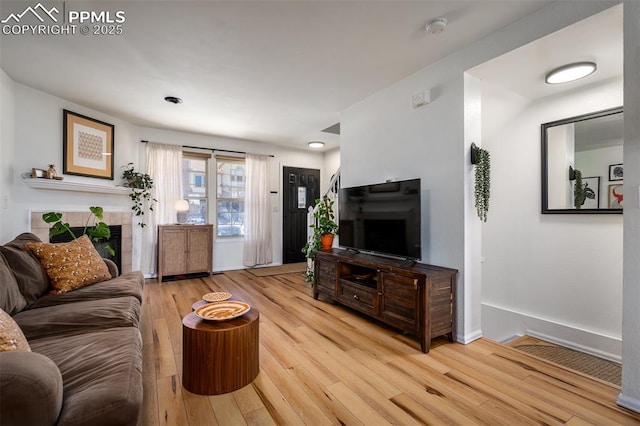 living area with light wood-style flooring and baseboards