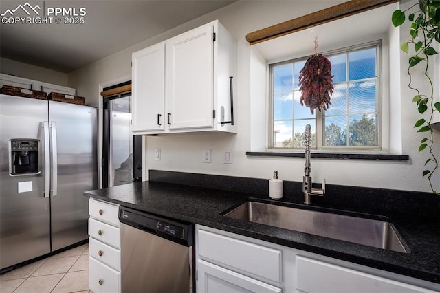 kitchen featuring light tile patterned floors, white cabinetry, stainless steel appliances, and a sink