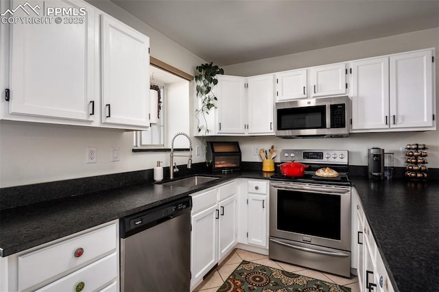 kitchen featuring stainless steel appliances, dark countertops, and a sink