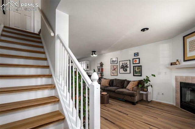 stairway featuring a fireplace and wood finished floors