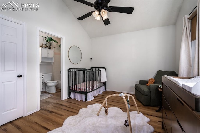 bedroom featuring dark wood-type flooring, vaulted ceiling, baseboards, and a ceiling fan