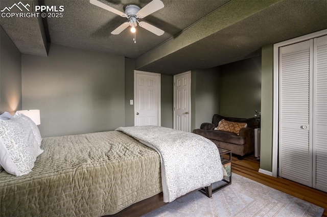 bedroom featuring a textured ceiling, a closet, a ceiling fan, and wood finished floors