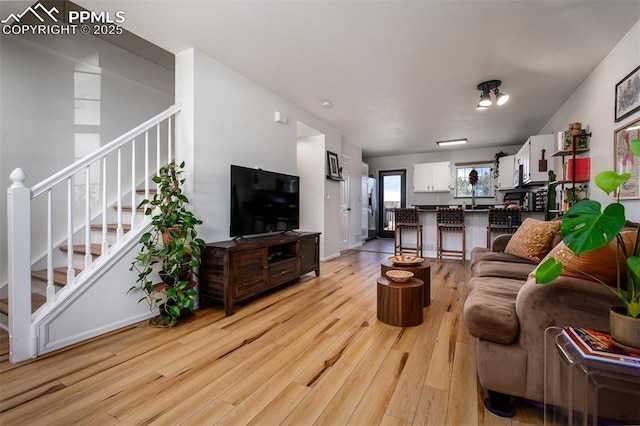 living area with stairway and light wood-style floors