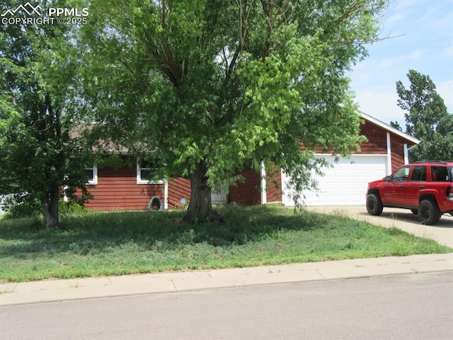 obstructed view of property featuring concrete driveway and an attached garage