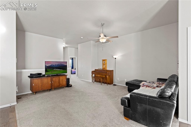 carpeted living area featuring a ceiling fan and baseboards