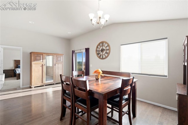 dining room featuring a chandelier, baseboards, lofted ceiling, and light wood-style floors