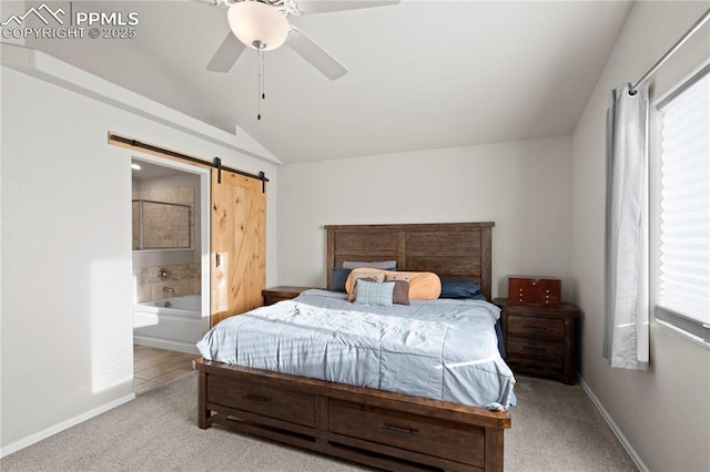 bedroom featuring a barn door, light colored carpet, ensuite bathroom, vaulted ceiling, and multiple windows