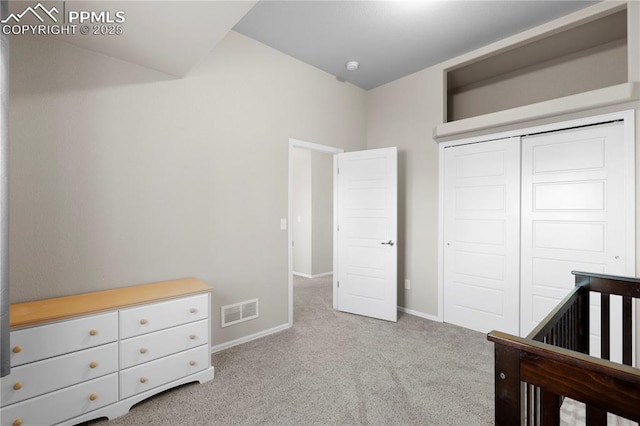 bedroom featuring baseboards, a closet, visible vents, and light colored carpet