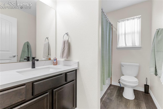 full bathroom with toilet, baseboards, wood finished floors, and vanity