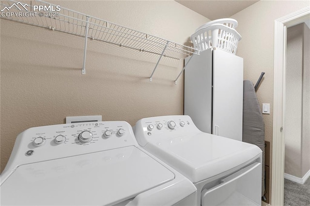 laundry area with a textured wall, laundry area, and separate washer and dryer