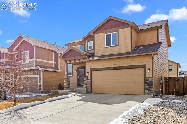 view of front of home with a shingled roof, concrete driveway, fence, a garage, and stone siding