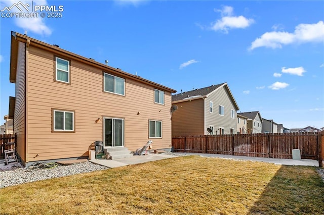 rear view of house with entry steps, a lawn, a patio, a fenced backyard, and a residential view