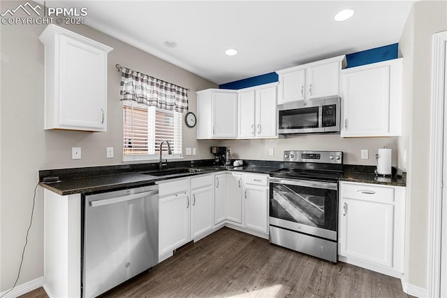 kitchen with dark wood-style floors, stainless steel appliances, a sink, and white cabinetry