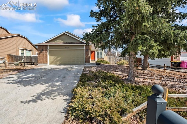 view of front facade with an attached garage, fence, concrete driveway, and brick siding