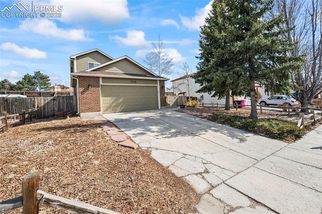 ranch-style home featuring a garage, driveway, brick siding, and fence