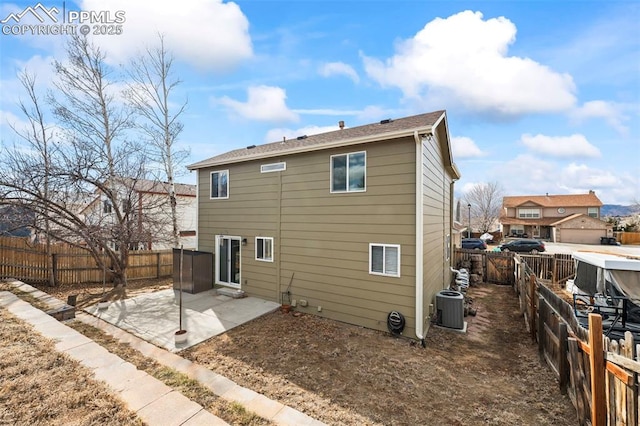 rear view of house with a fenced backyard, a patio, and central air condition unit