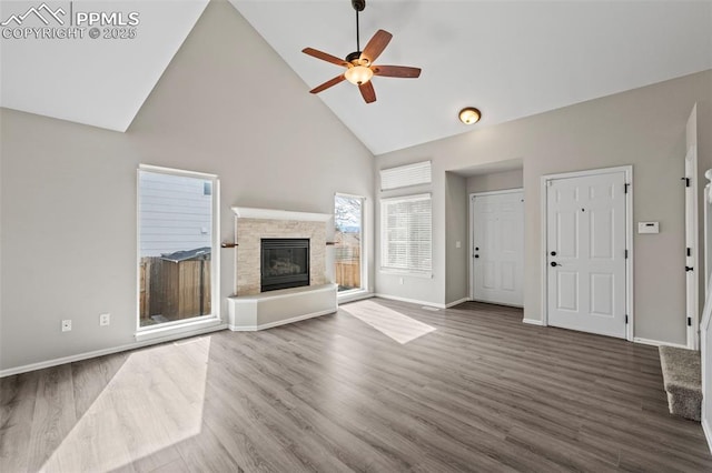 unfurnished living room with ceiling fan, a fireplace, high vaulted ceiling, and dark wood finished floors