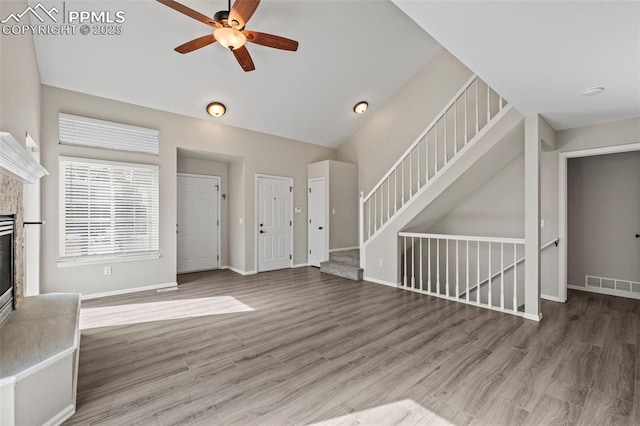 unfurnished living room featuring visible vents, a stone fireplace, baseboards, and stairs