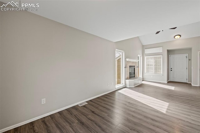 unfurnished living room with dark wood-type flooring, visible vents, a fireplace, and baseboards