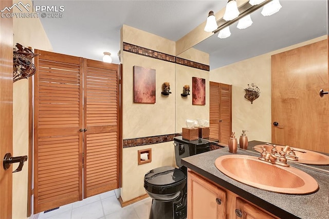 bathroom with vanity, toilet, and tile patterned floors