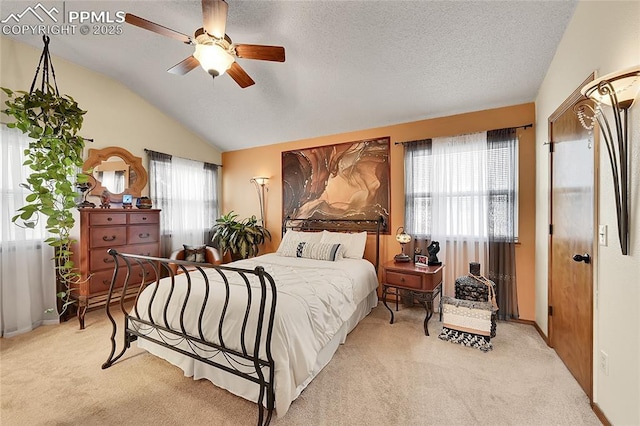 bedroom with multiple windows, vaulted ceiling, a textured ceiling, and light colored carpet