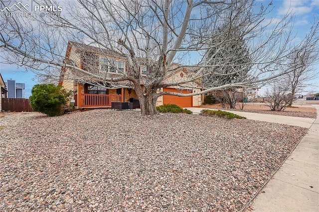 view of front of house with concrete driveway and fence