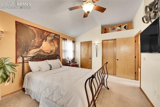 bedroom featuring vaulted ceiling, ceiling fan, multiple closets, and light colored carpet