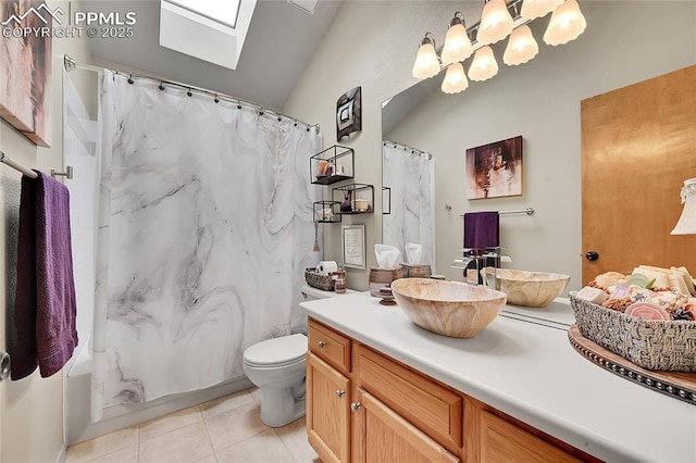 full bathroom featuring toilet, a skylight, tile patterned flooring, and vanity