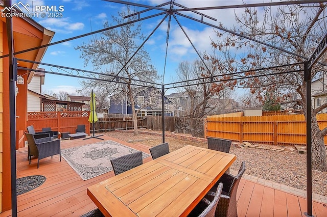 deck featuring outdoor dining space and a fenced backyard