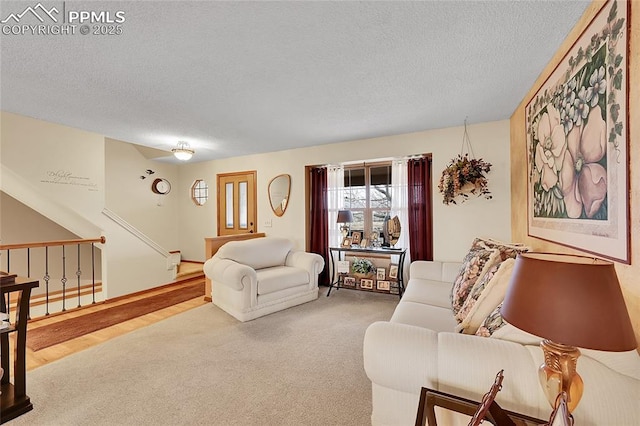 carpeted living area with a textured ceiling and stairs