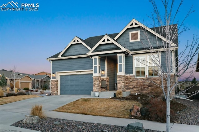 craftsman house featuring a garage, stone siding, and concrete driveway