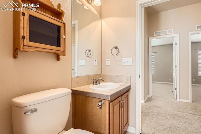 bathroom with baseboards, visible vents, vanity, and toilet