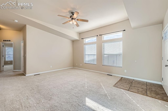 empty room with a ceiling fan, visible vents, light carpet, and baseboards