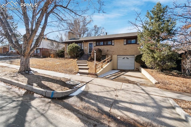 view of front of house with concrete driveway, a chimney, and an attached garage