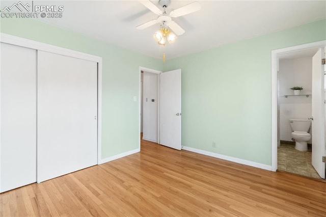 unfurnished bedroom with a closet, light wood-type flooring, connected bathroom, and baseboards