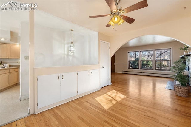 interior space with a baseboard heating unit, arched walkways, light wood-style floors, and ceiling fan