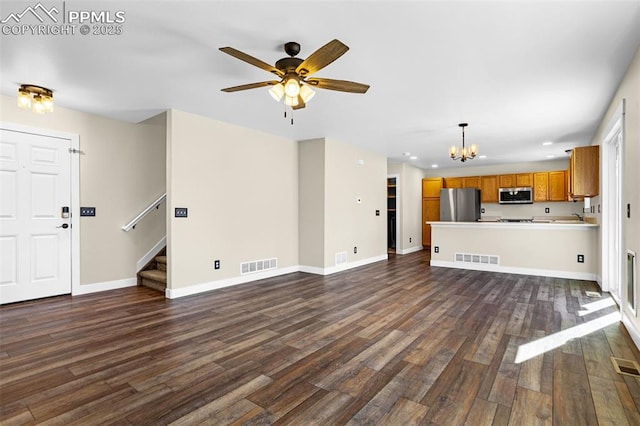 unfurnished living room featuring dark wood-style floors, stairway, visible vents, and baseboards