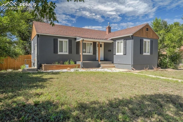 bungalow featuring a porch, a front yard, fence, and a chimney