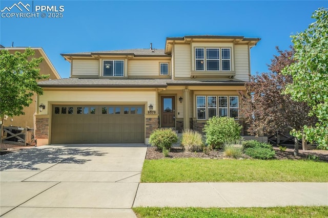 prairie-style home with an attached garage, concrete driveway, and stone siding