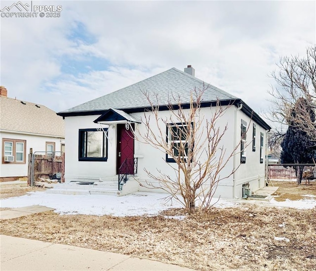1108 W 16th St, Pueblo, CO 81003 - back of property featuring roof with shingles, fence, and stucco siding