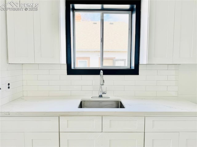 1108 W 16th St, Pueblo, CO 81003 - kitchen featuring white cabinets, a sink, and light stone countertops