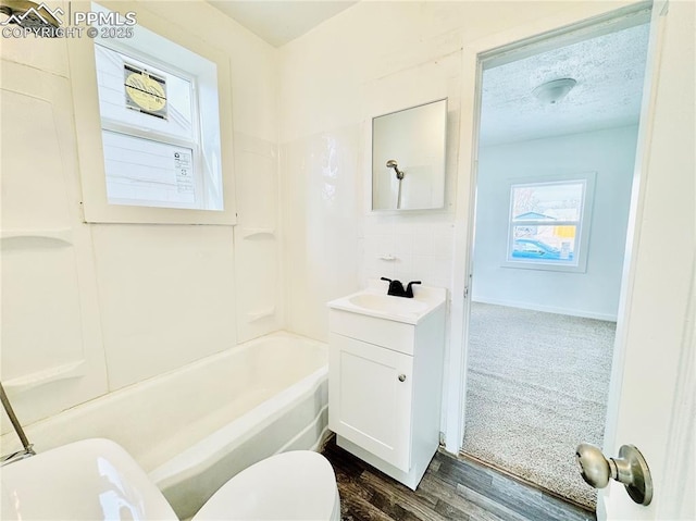 1108 W 16th St, Pueblo, CO 81003 - bathroom featuring a textured ceiling, toilet, wood finished floors, vanity, and shower / bathing tub combination