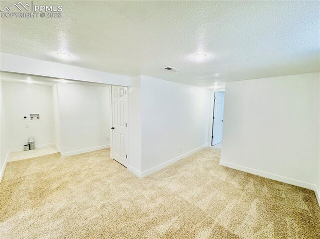 1108 W 16th St, Pueblo, CO 81003 - finished below grade area with light carpet, a textured ceiling, visible vents, and baseboards