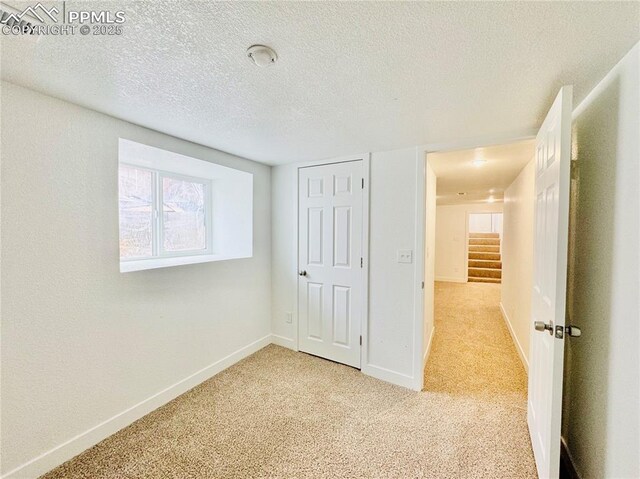 1108 W 16th St, Pueblo, CO 81003 - unfurnished bedroom with a textured ceiling, baseboards, and light colored carpet